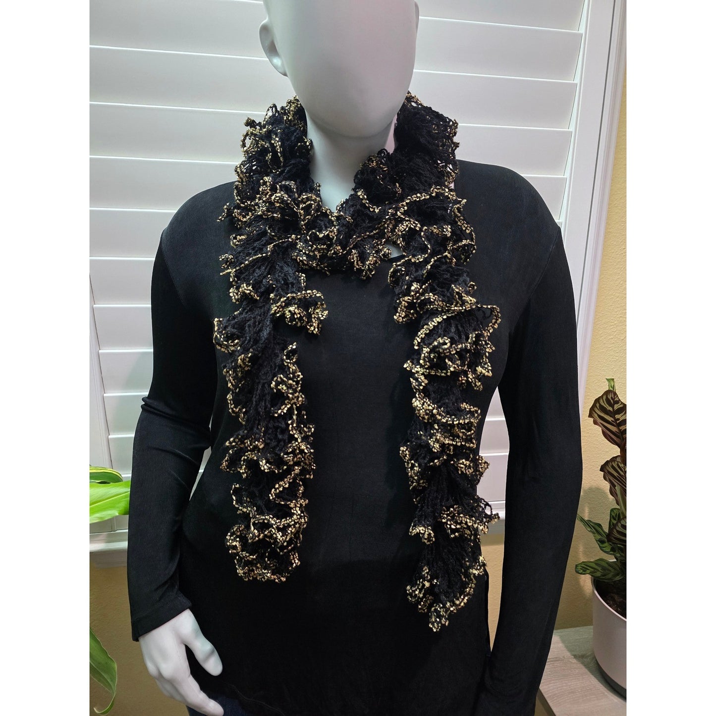 Black and gold ruffled scarf styled around the neck