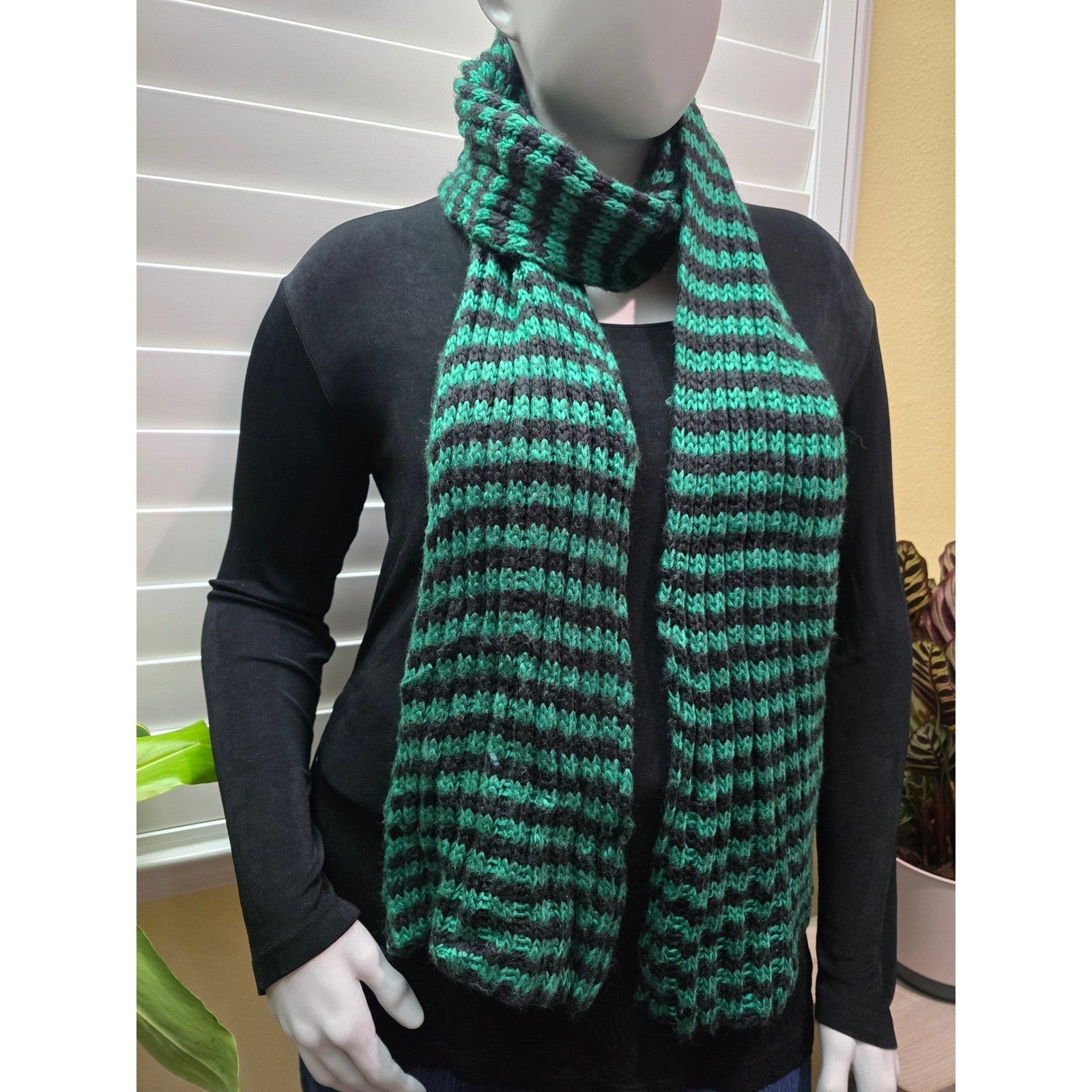 Green and black ribbed knit scarf styled loose